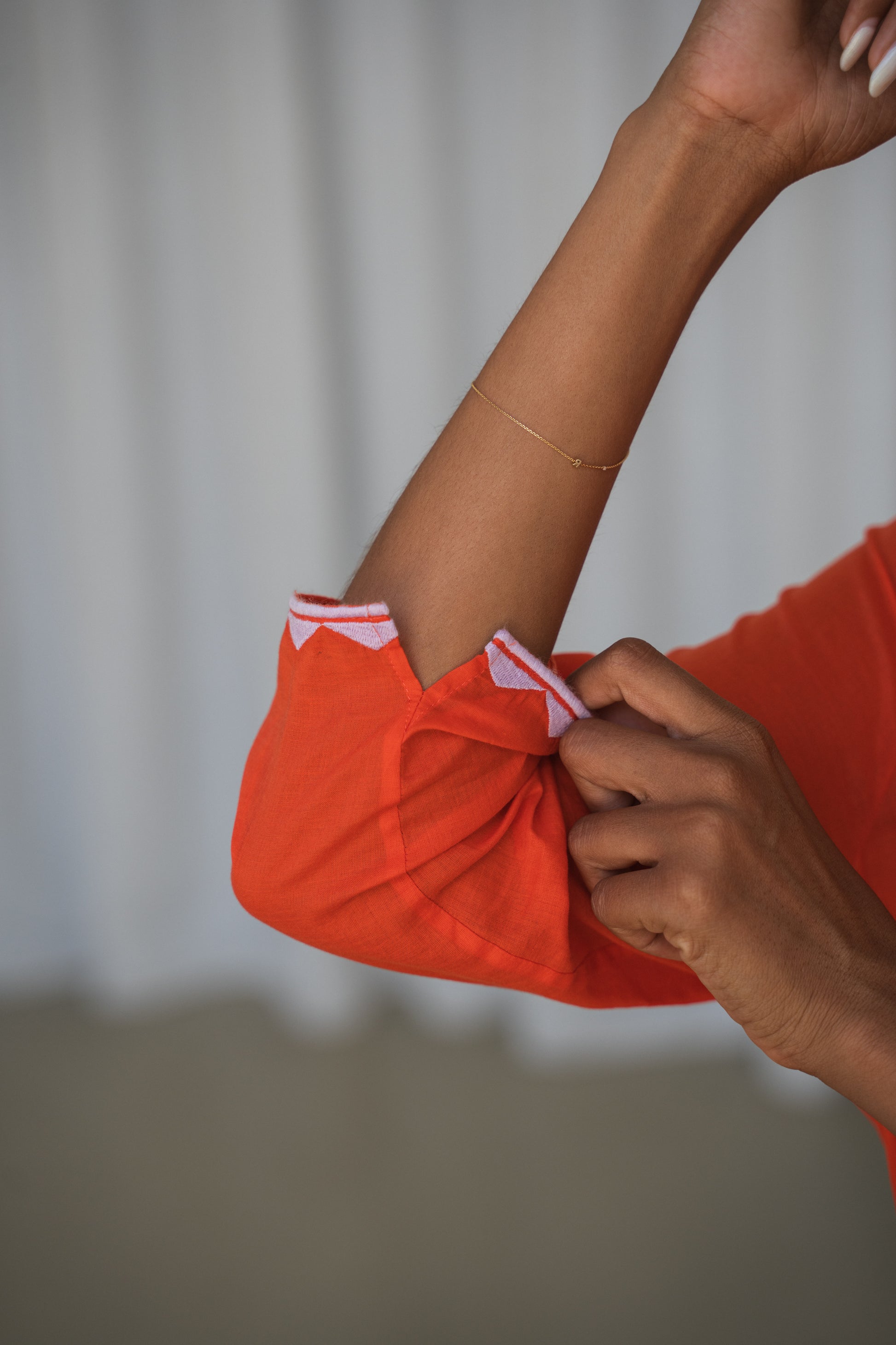 LILLY PILLY woman in a spritz Callie cotton dress showing the sleeve details against a neutral background