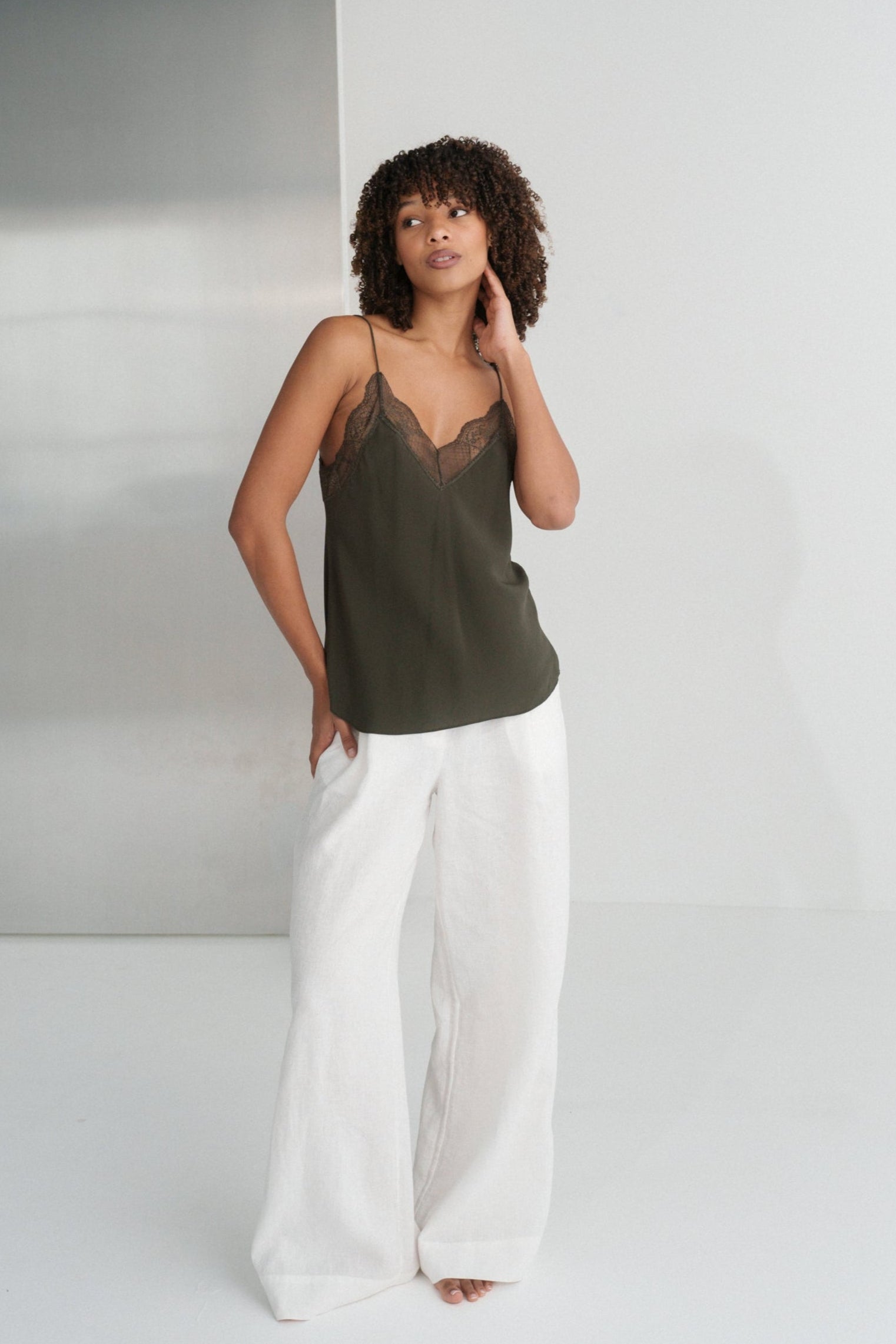 LILLY PILLY woman wearing Frankie silk cami in khaki and Oli linen pants in ivory