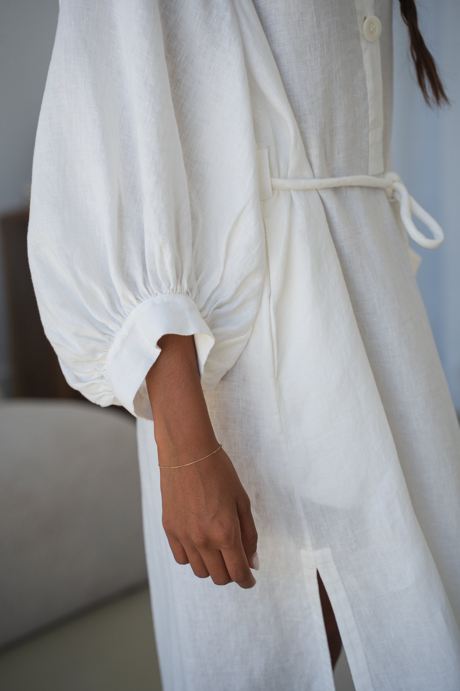 Woman in an ivory Mae linen dress in studio close up of side view