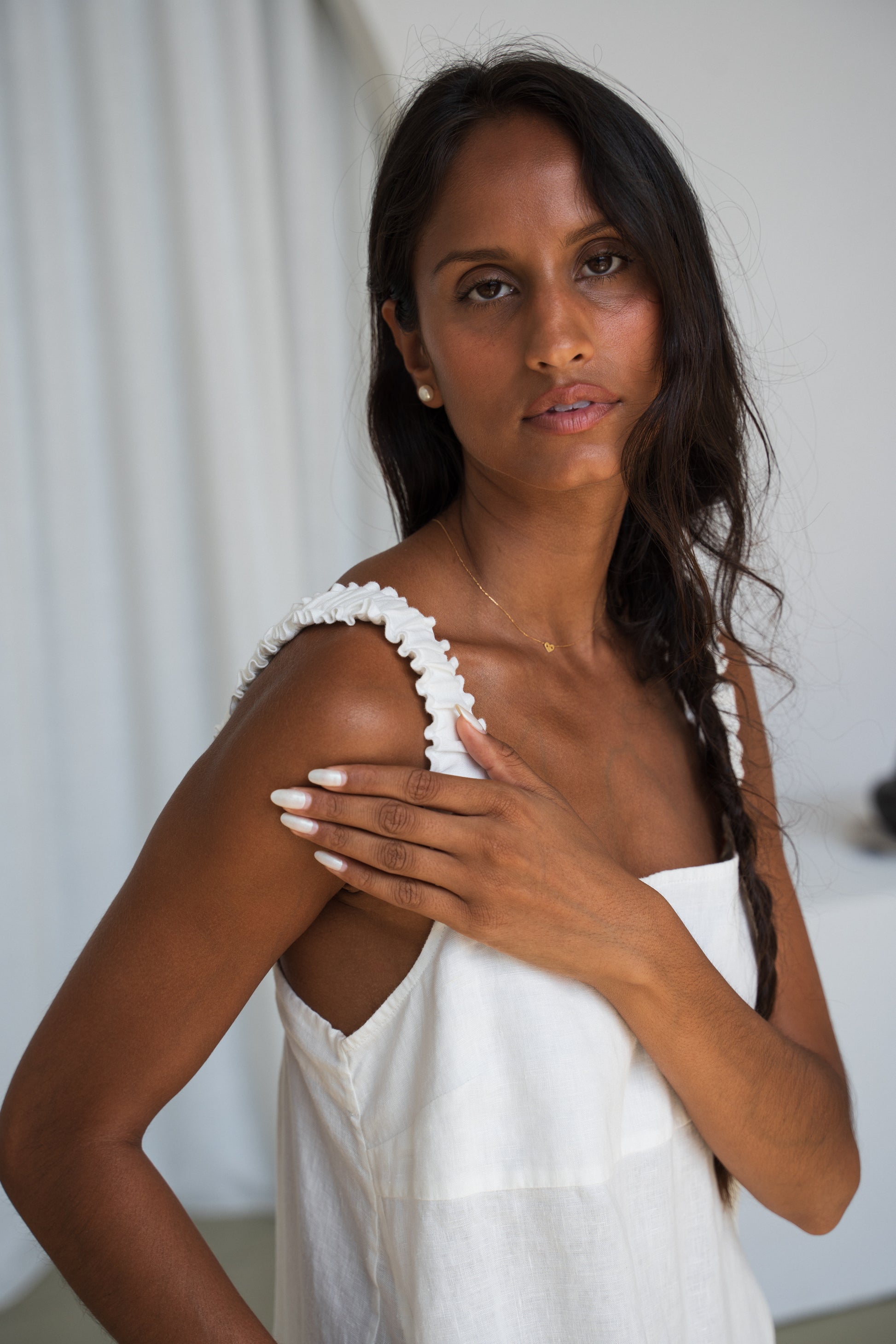 Close up of shoulder strap details of LILLY PILLY woman wearing an ivory Zahra linen dress