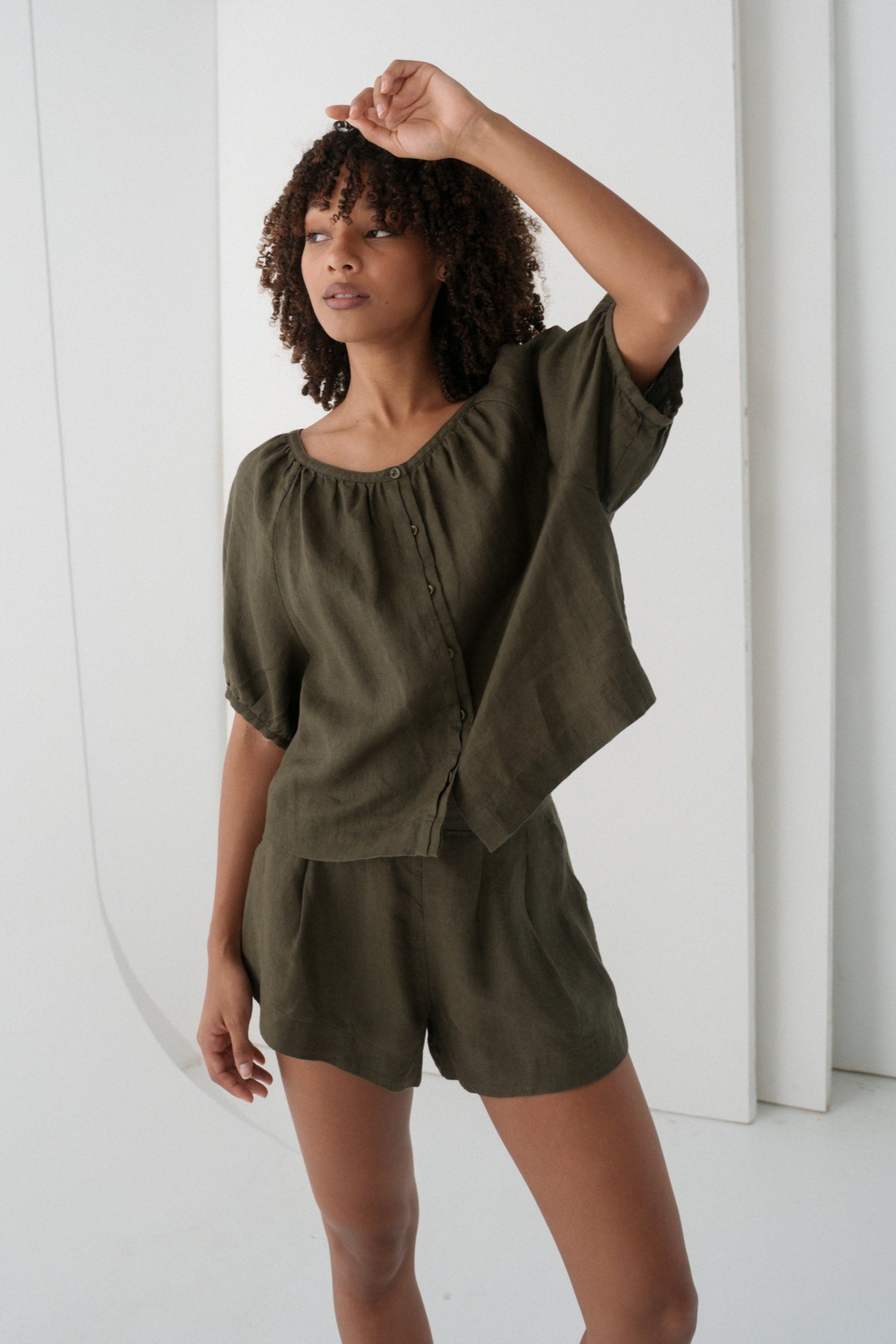 LILLY PILLY woman wearing a khaki Pia linen shirt top and Gaia shorts outfit against a white background