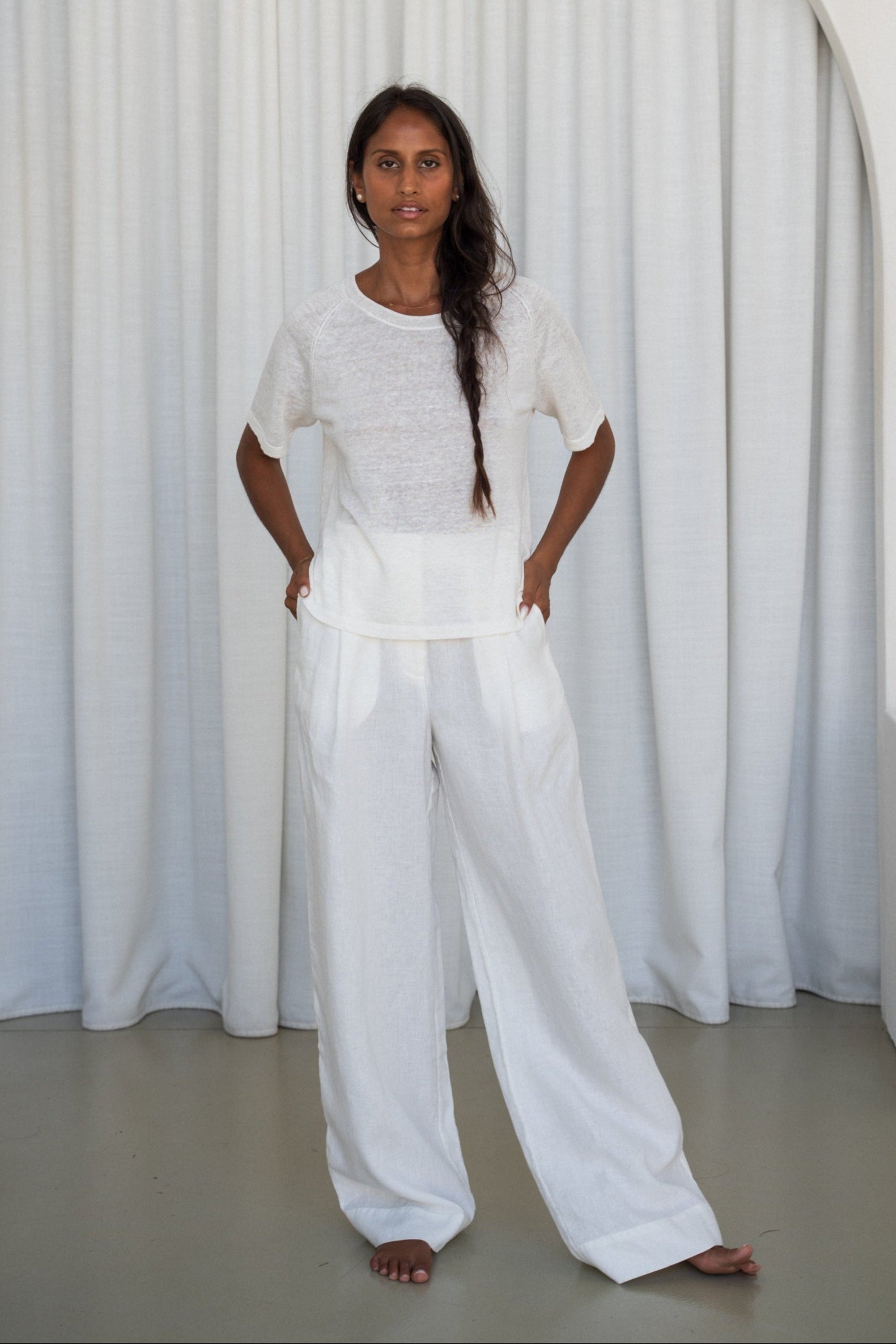 Person wearing a Grace knit top in Ivory and Oli ivory pants set against a plain white background