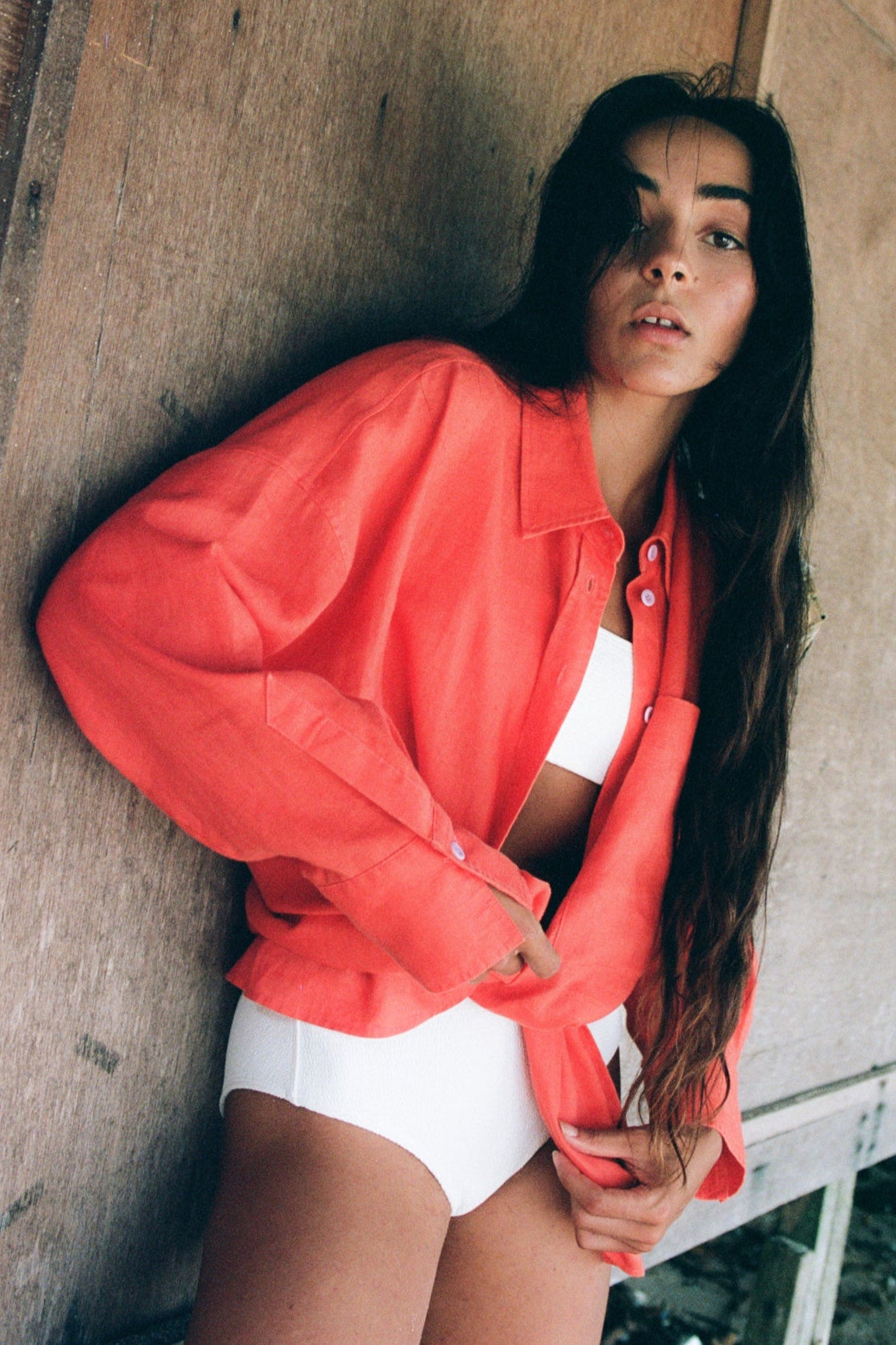 LILLY PILLY woman wearing a spritz Kirra linen shirt leaning against a wall.