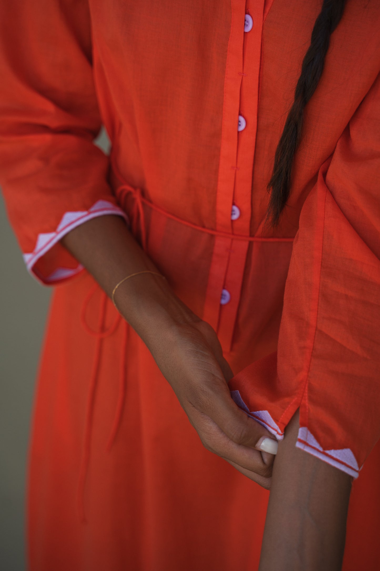 LILLY PILLY woman in a spritz Callie cotton dress close-up of orchid sleeve trim on a neutral background