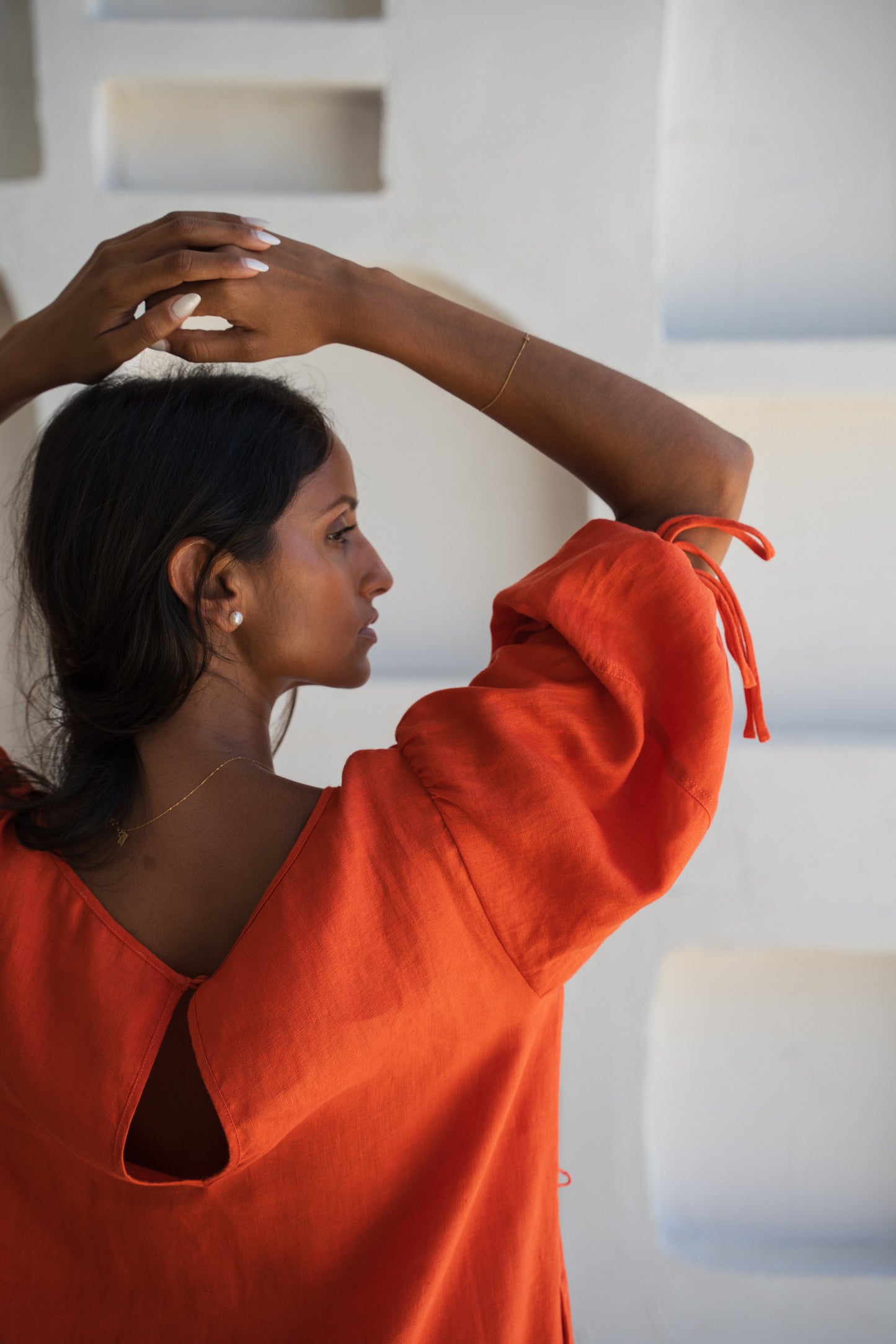 LILLY PILLY woman wearing our spritz Charlotte linen dress raising her arm to show sleeve details