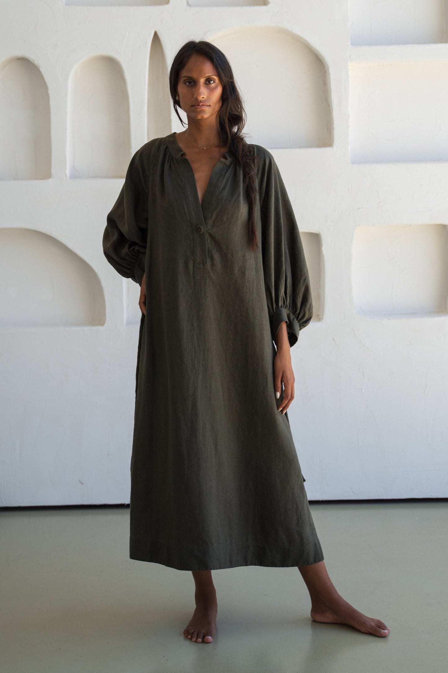 Woman wearing a khaki Mae linen dress in studio