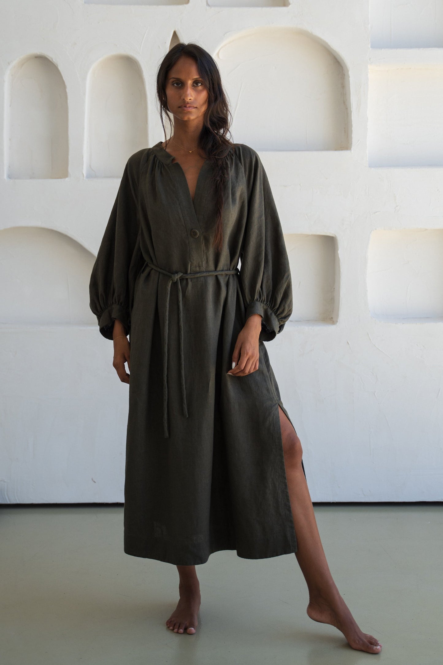 Woman wearing a khaki Mae linen dress in studio