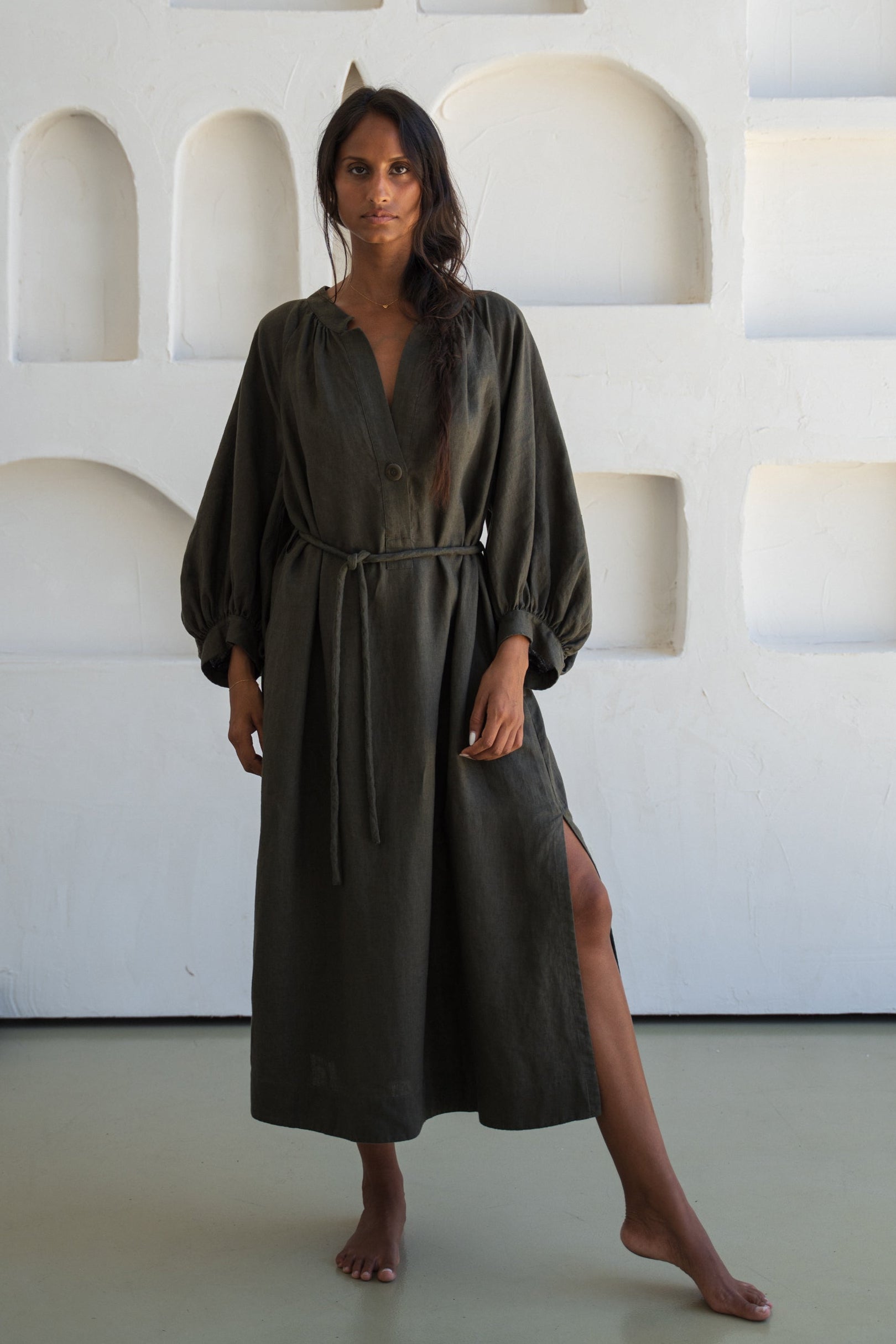 Woman wearing a khaki Mae linen dress in studio